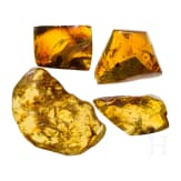 Four large amber stones, three with inclusions