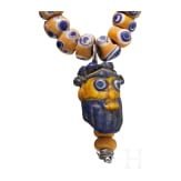 A modern-stringed necklace of 69 eye beads and a Phoenician face bead, early Celtic, partly Mediterranean, 5th - 4th century B.C.