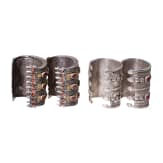 Two pairs of partially fire-gilt Turkmen silver and carnelian cuff bracelets, circa 1900