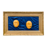 A framed amber carving showing two faces, Erbach/Hanau, 20th century