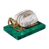 A Russian gilt-bronze sledge-shaped paperweight on a malachite stand, 20th century