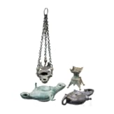 Three bronze oil lamps with hanging devices and a bronze candle holder, Roman and early Byzantine, 1st &ndash; 7th century A.D.