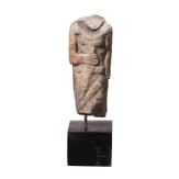 Neo-Assyrian statuette of a ruler, carved from a variety of alabaster, with his right arm bent and resting on the hilt of a dagger, 9th century B.C.