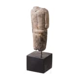Neo-Assyrian statuette of a ruler, carved from a variety of alabaster, with his right arm bent and resting on the hilt of a dagger, 9th century B.C.