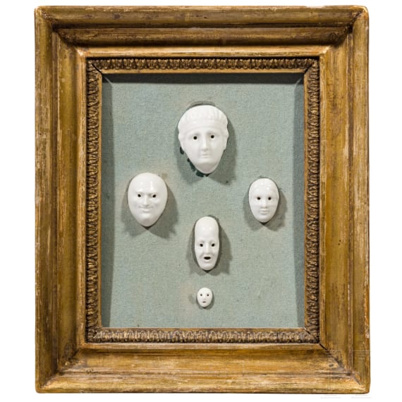A set of five porcelain masks designed by August G&ouml;hring (1891 - 1965), mounted in carved and gilded Neoclassical frame, Nymphenburg, 20th century