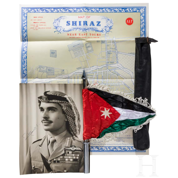 A large photo of King Hussein I, a vehicle standard, a map