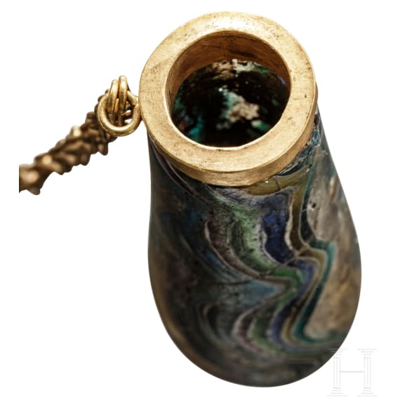A Roman glass unguent bottle with figural gold lid, 1st century