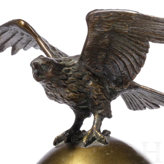 Kleiner Tischadler auf Weltkugel