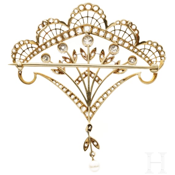 A fan-shaped gold and diamond brooch with a pearl