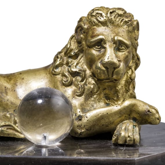 A South German reclining bronze lion with orb, probably circa 1900