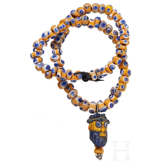 A modern-stringed necklace of 69 eye beads and a Phoenician face bead, early Celtic, partly Mediterranean, 5th - 4th century B.C.