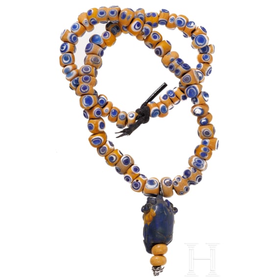 A modern-stringed necklace of 69 eye beads and a Phoenician face bead, early Celtic, partly Mediterranean, 5th - 4th century B.C.