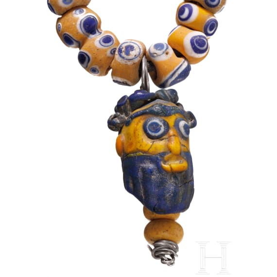 A modern-stringed necklace of 69 eye beads and a Phoenician face bead, early Celtic, partly Mediterranean, 5th - 4th century B.C.