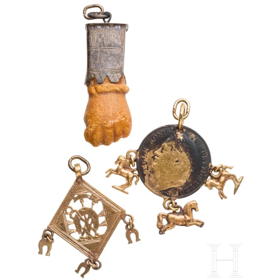 A Roman amber fig hand, 1st - 3rd century, in 19th century setting, and two amulets, 19th century