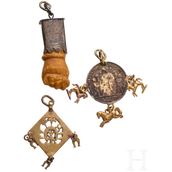A Roman amber fig hand, 1st - 3rd century, in 19th century setting, and two amulets, 19th century
