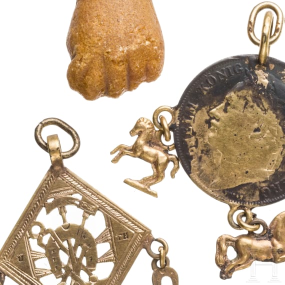 A Roman amber fig hand, 1st - 3rd century, in 19th century setting, and two amulets, 19th century