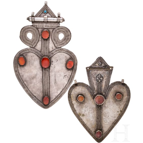 Two heart-shaped and partially gilt Turkmen silver and carnelian Teke "asyk" back-pendants, circa 1900