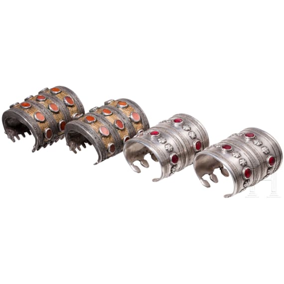 Two pairs of partially fire-gilt Turkmen silver and carnelian cuff bracelets, circa 1900