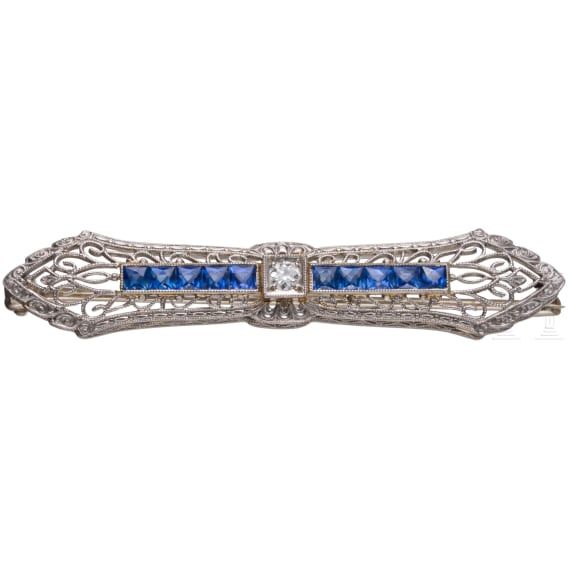 A 14ct gold brooch set with sapphires and diamond