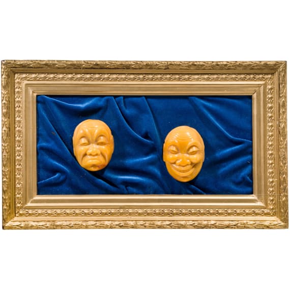 A framed amber carving showing two faces, Erbach/Hanau, 20th century