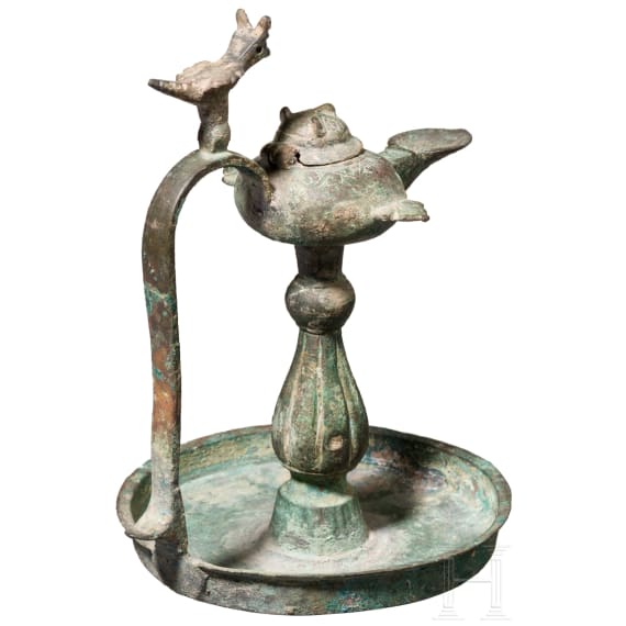 Bronze oil lamp on a disc-shaped base with floral and figurative decoration, Seljuk, 12th&ndash;13th centuries