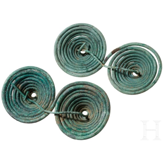 A pair of Early Iron Age bronze fibulae with a double spiral and an olive-green patina, 9th&ndash;8th centuries B.C.