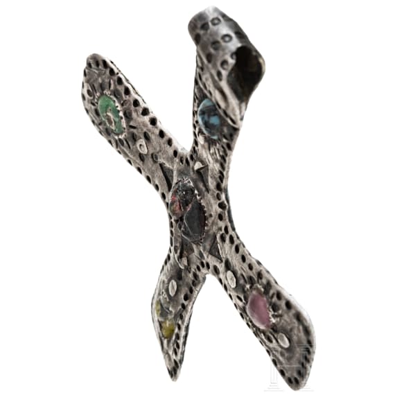 A silver cross-shaped pendant with punched decoration and inlays, Viking, 10th century.