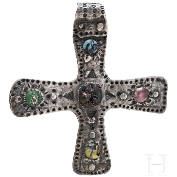 A silver cross-shaped pendant with punched decoration and inlays, Viking, 10th century.