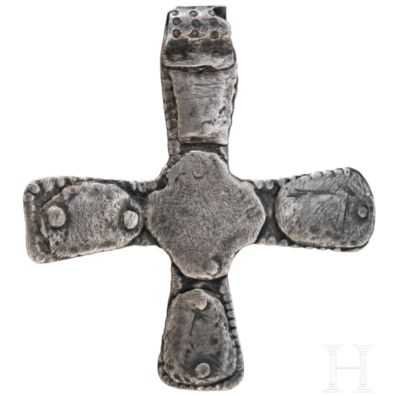 A silver cross-shaped pendant with punched decoration and inlays, Viking, 10th century.
