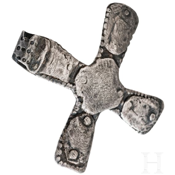 A silver cross-shaped pendant with punched decoration and inlays, Viking, 10th century.