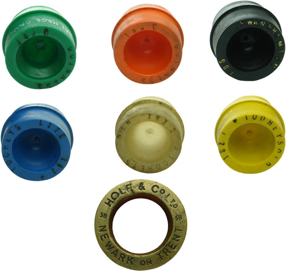 Six plastic plugs from Tooheys Sydney kegs and a brass UK barrel bung