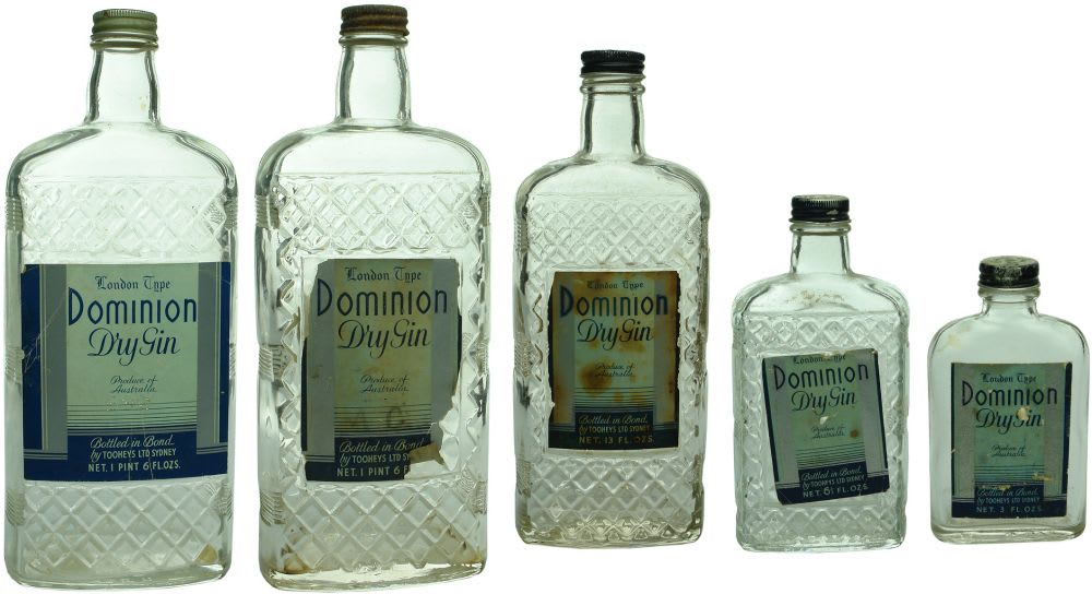 Five labelled Dominion Dry Gin bottles. Tooheys Ltd., Sydney.