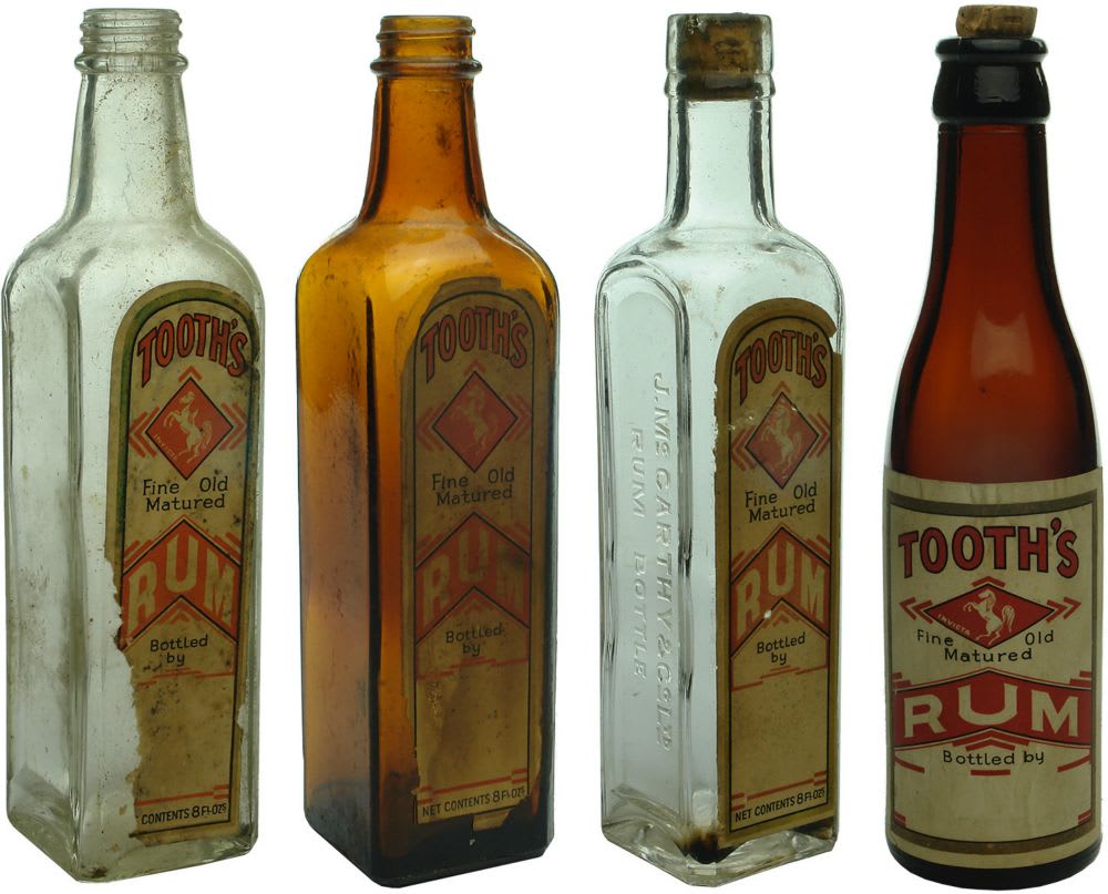 Four labelled Tooth's Fine Old Matured Rum Bottles.