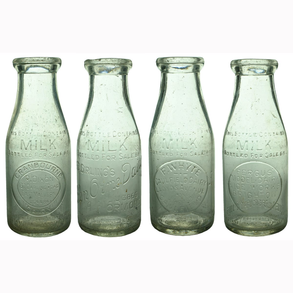 Four wide mouth Pint Milk Bottles: Dixon, East Malvern; Glen Orme Dairy; Whyte Caulfield Dairy; Fergus' Model Dairy.