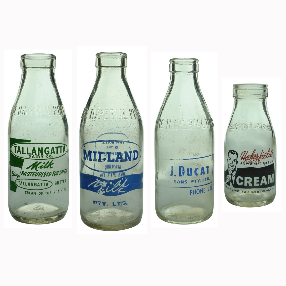 Four ceramic label milk bottles: Tallangatta; Midland; Ducat; Haberfields.