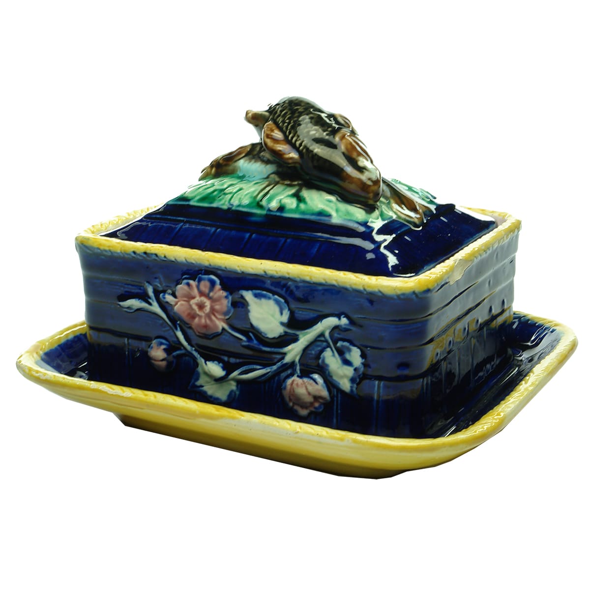 Majolica dish. Handle to lid is two fish. Flowers on sides of dish itself.