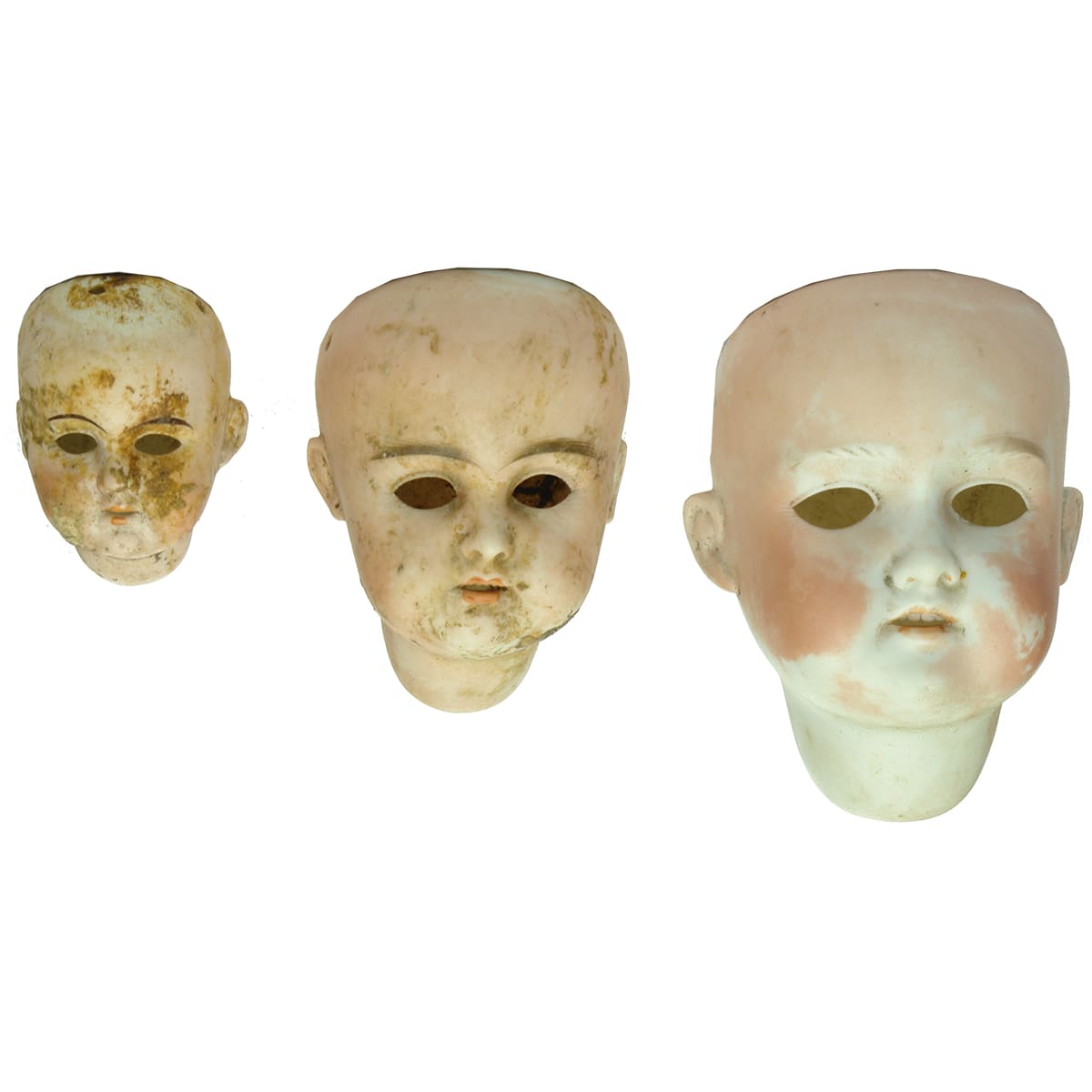 Three different sized bisque Dolls Heads.