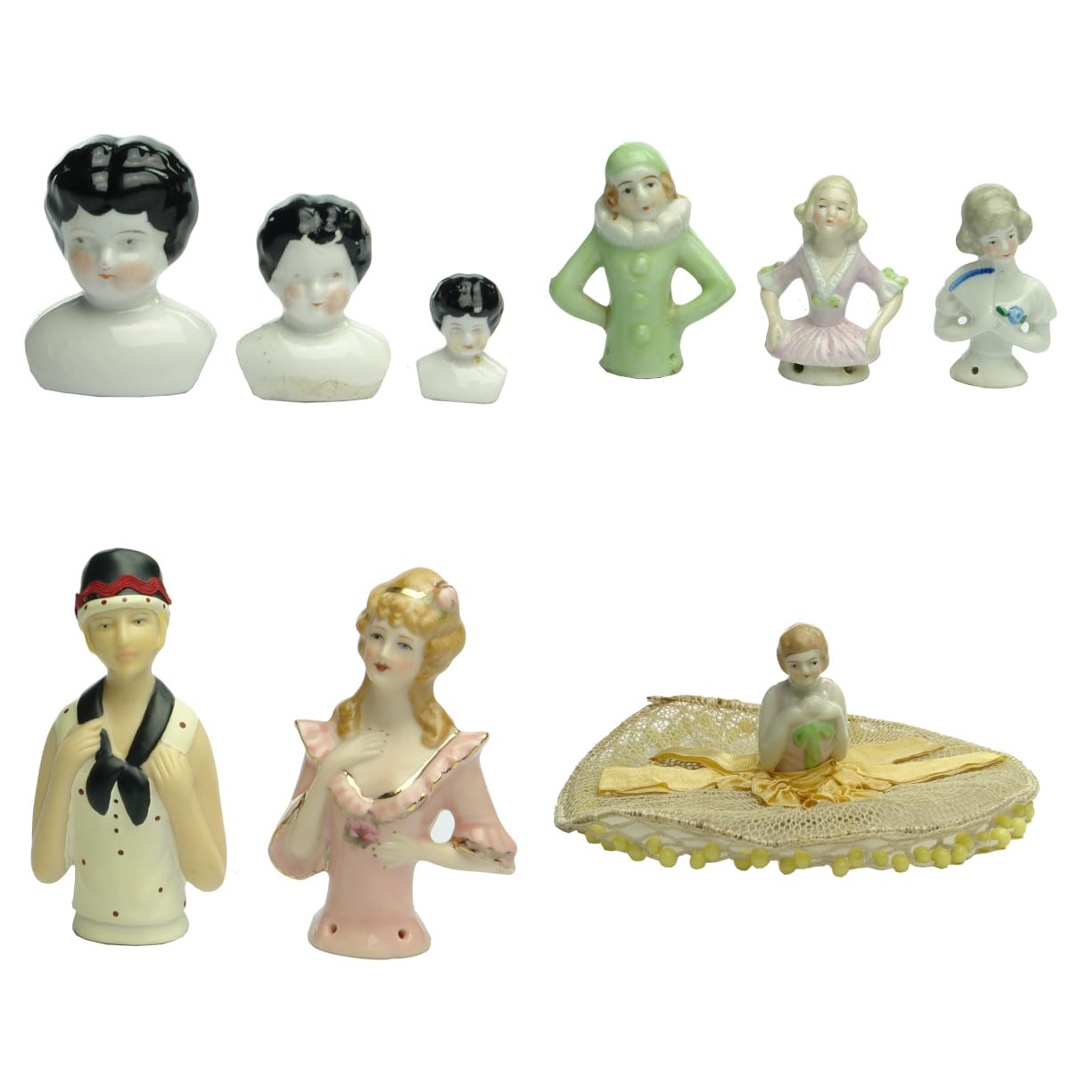 Nine Dolls. Three black haired porcelain dolls heads and six tea cosy dolls.