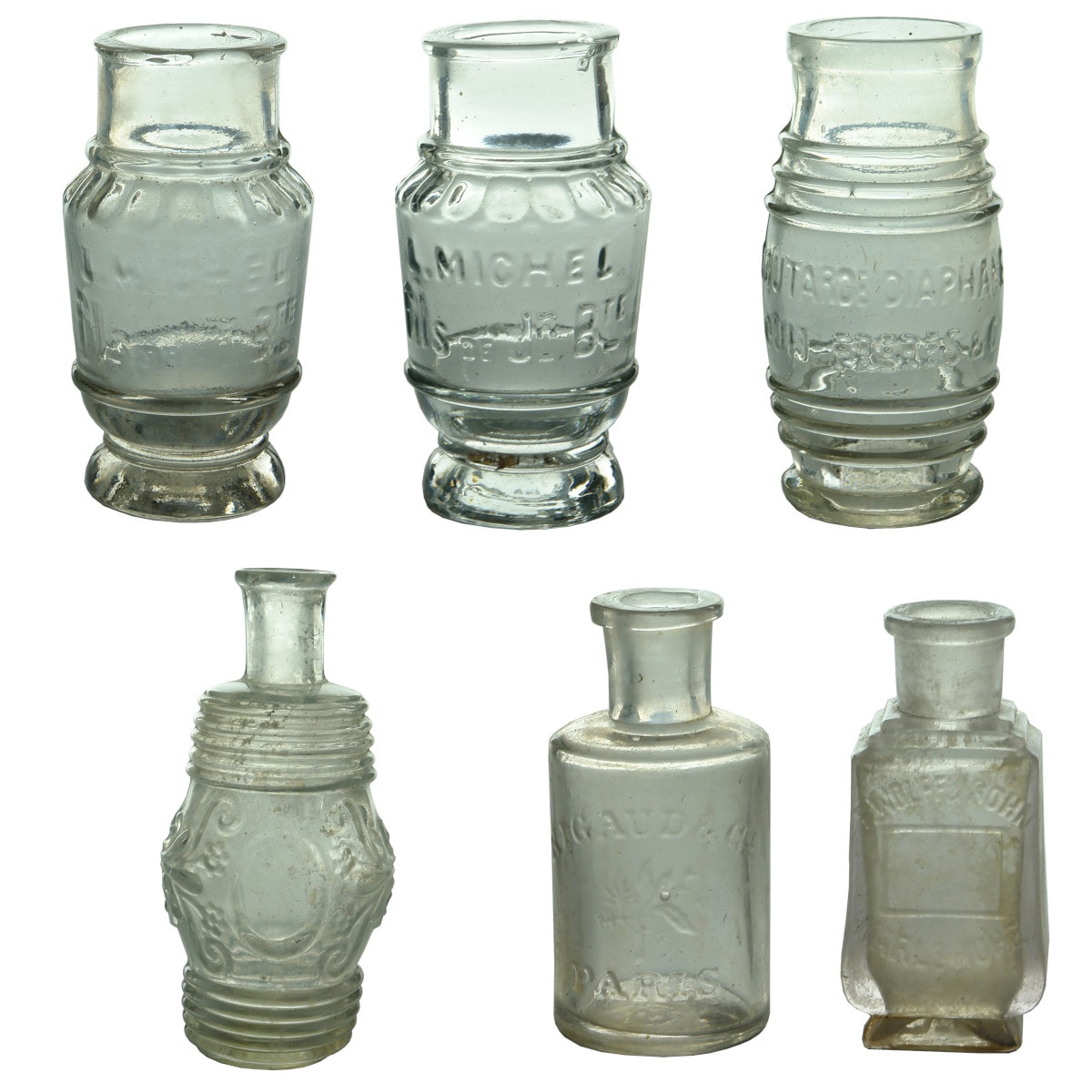 6 Clear/Flint glass bottles: 3 French Mustard Jars: 2 x L. Michel; Louit Freres & Co. and 3 Perfumes, Fancy large Barrel shape with Pontil scar; Rigaud, Paris; Wolff & Sohn, Carlsruhe.