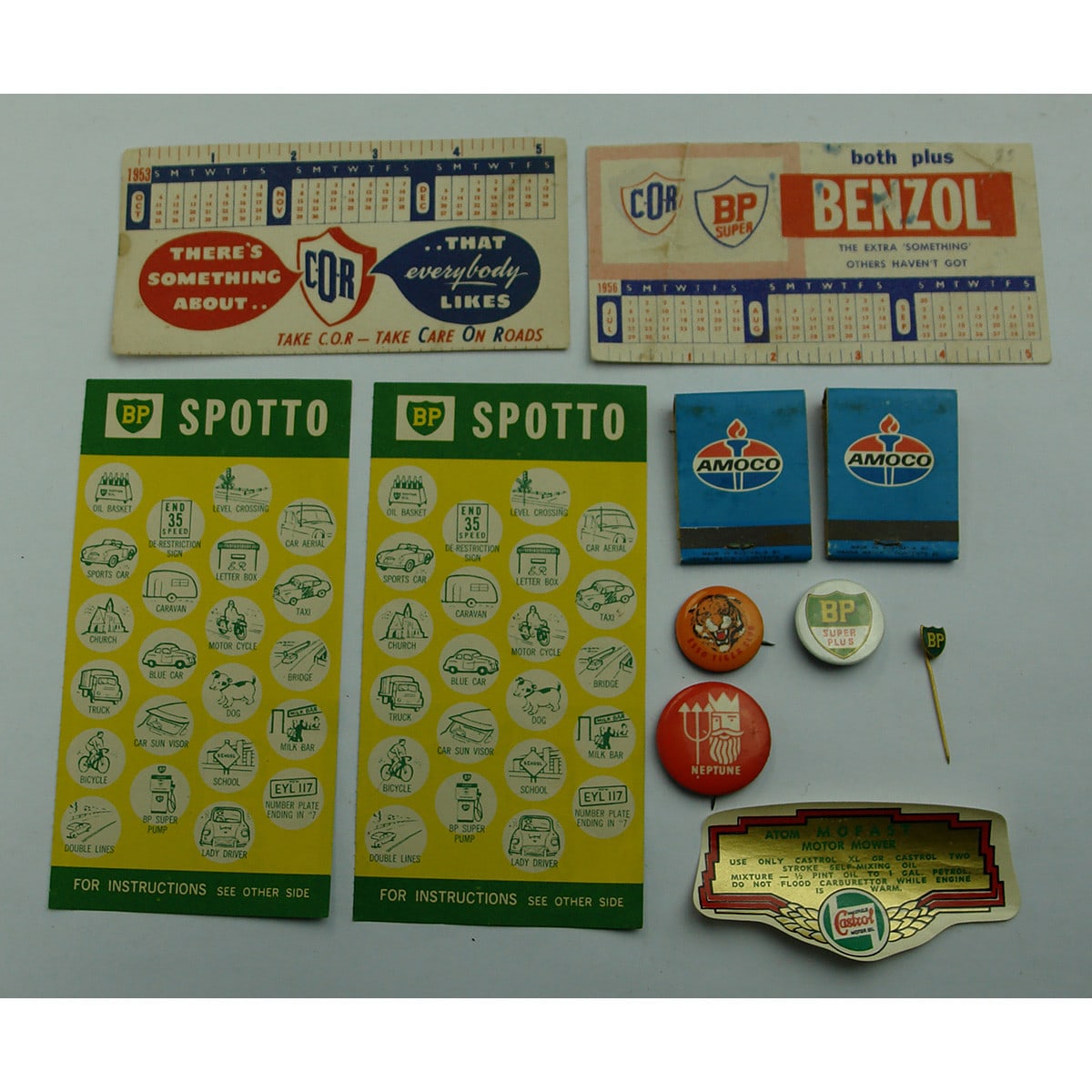 11 Petroliana ephemera and badges. BP Spotto Games; COR Blotters; Amoco Matchbooks; Neptune, Esso & BP Badges; Castrol Atom Mofast label.
