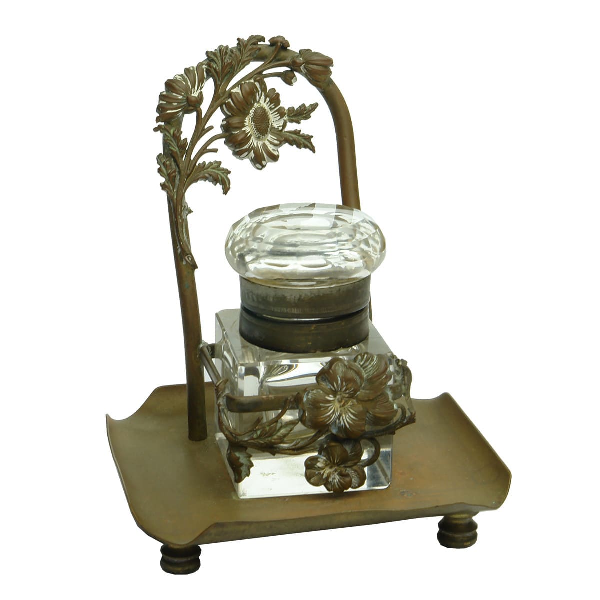 Ink. Heavy cut glass inkwell with brass hinged fitting and very fancy brass stand with floral decoration.