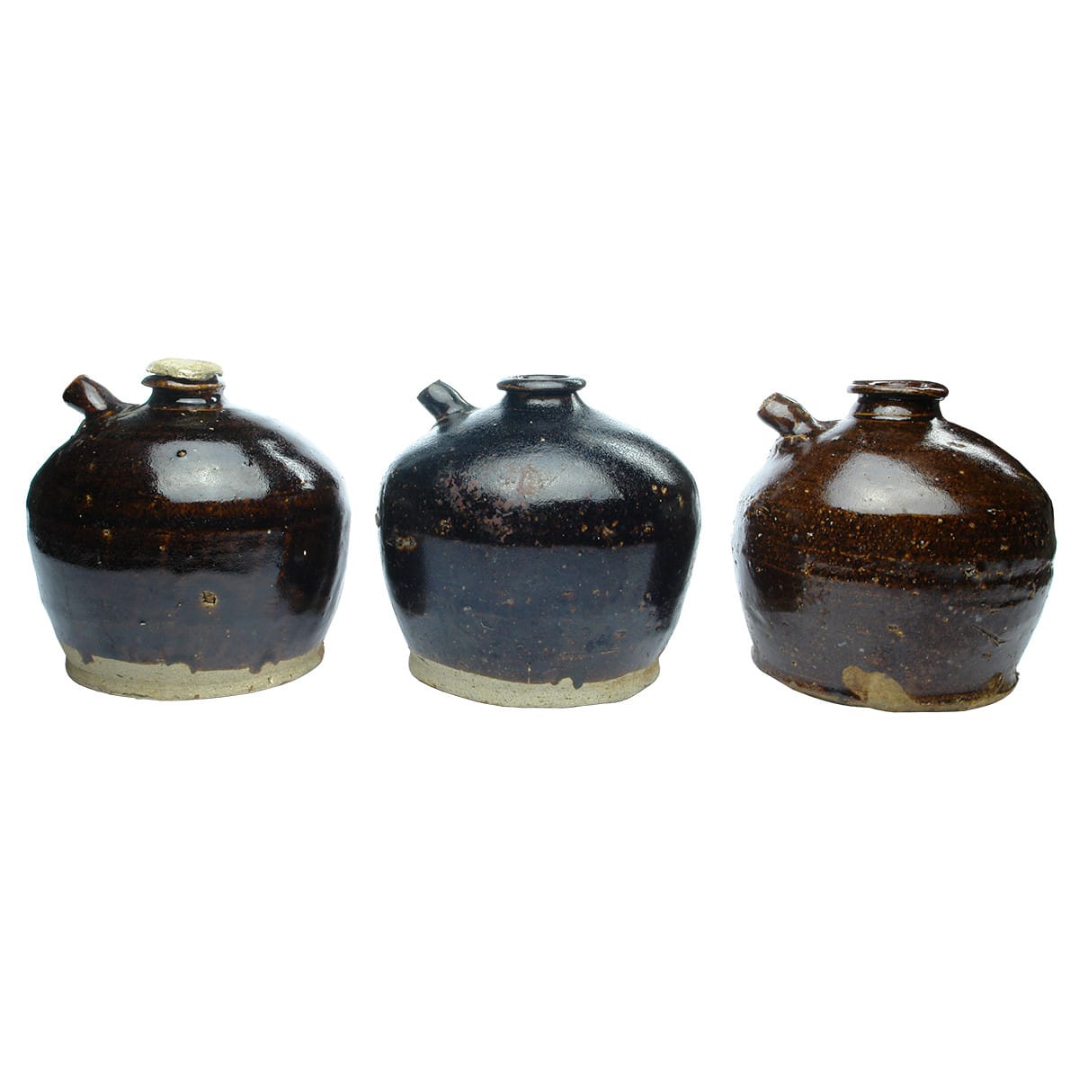 3 Chinese Soy Sauce Jars. One with what I assume is its original little cement type stopper. Differing Brown Glazes.