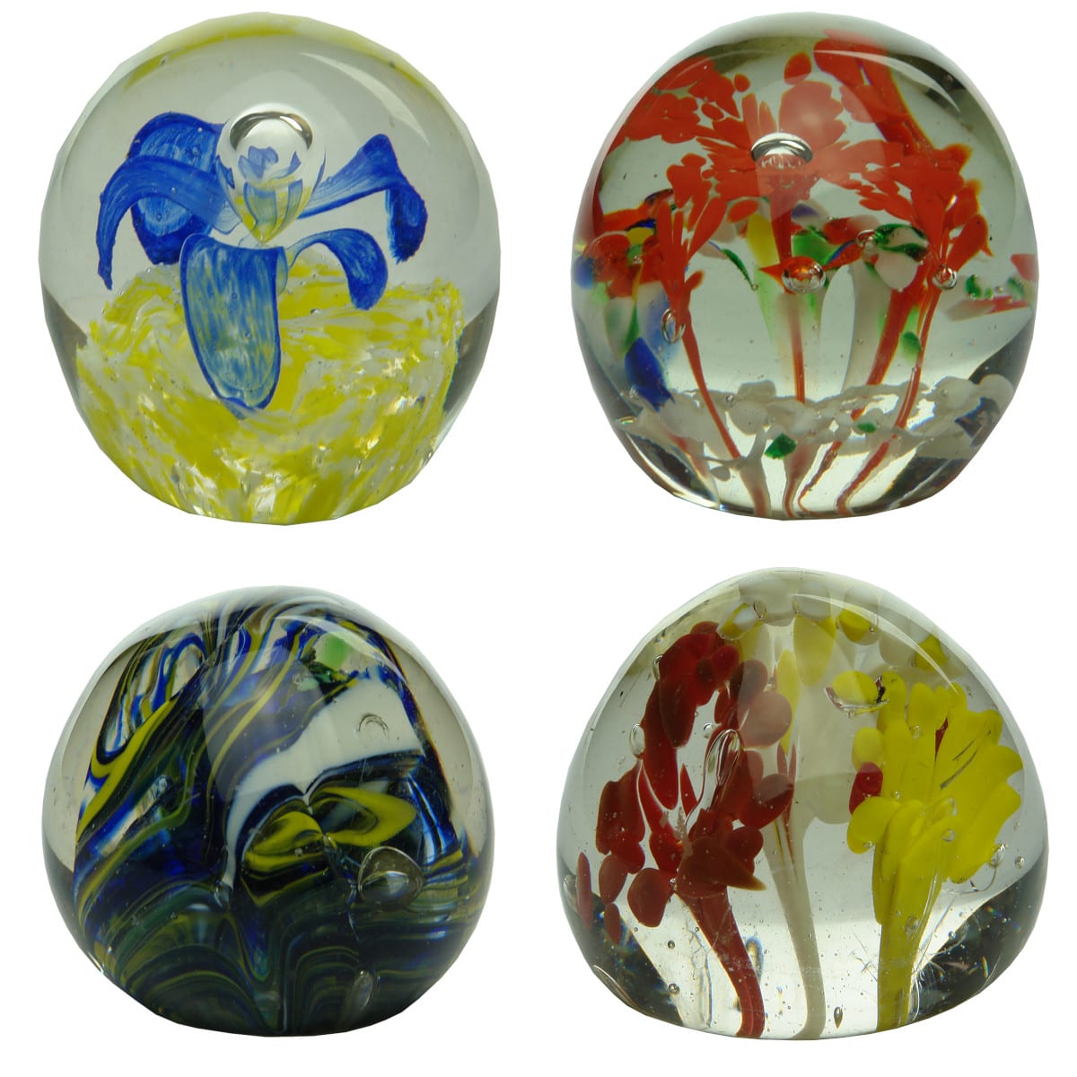4 Glass Paperweights. Blue flower on yellow; Squashed egg, red flowers; Swirled Blue, Yellow, White; Yellow & White Flowers.