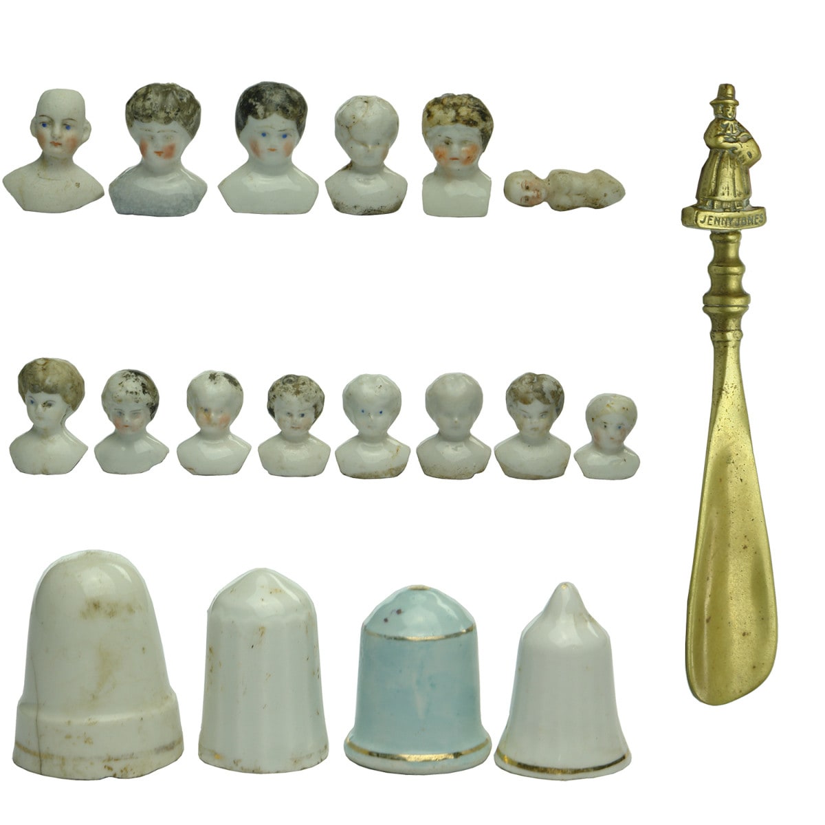 19 items: 14 Dolls heads, 4 candle snuffers and a brass shoe horn with Jenny Jones figure at top.