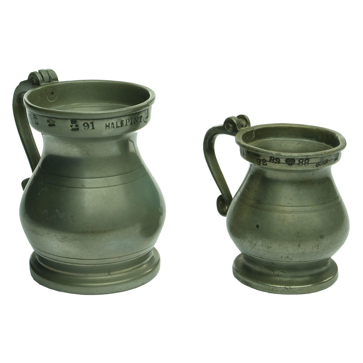 Pair of heavy pewter measuring jugs. Half Pint & Spence. Lots of official stamps around the rims. Both missing lids.