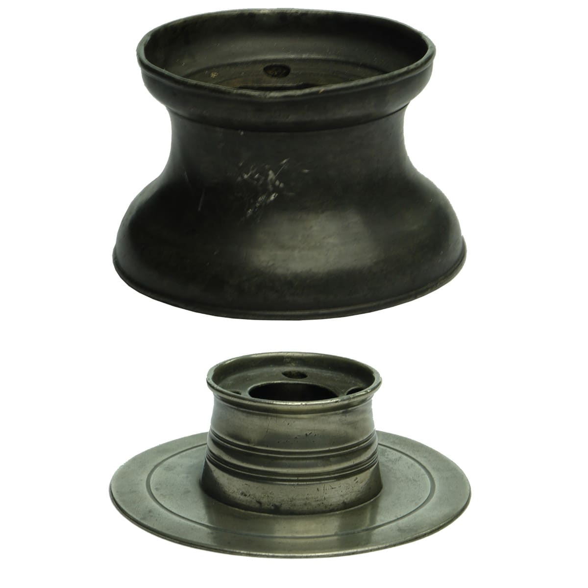 2 Pewter Inkwells. No lids. Capstan shape and round one with a wide plate base attached.