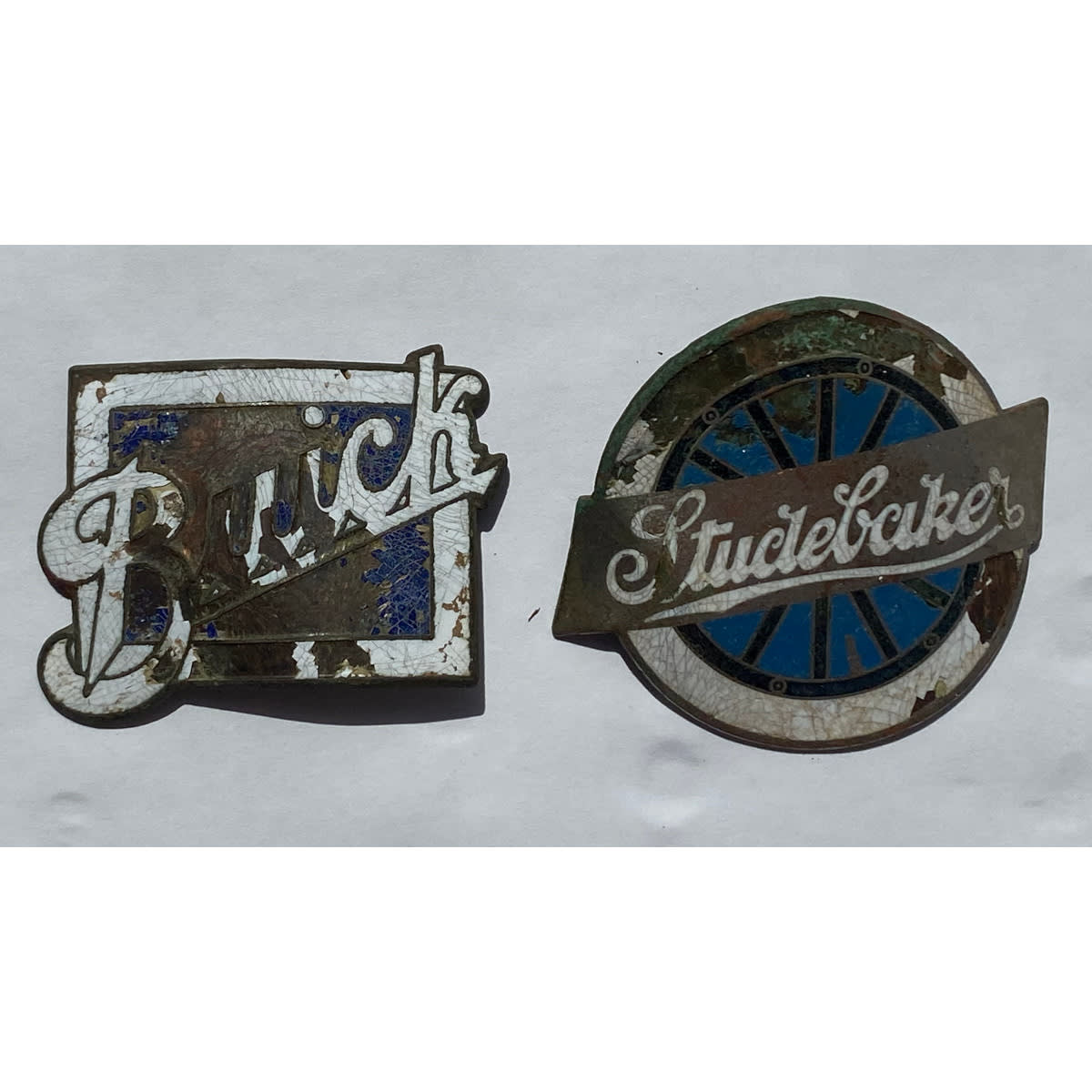 2 enamel Car Badges: Studebaker & Buick.