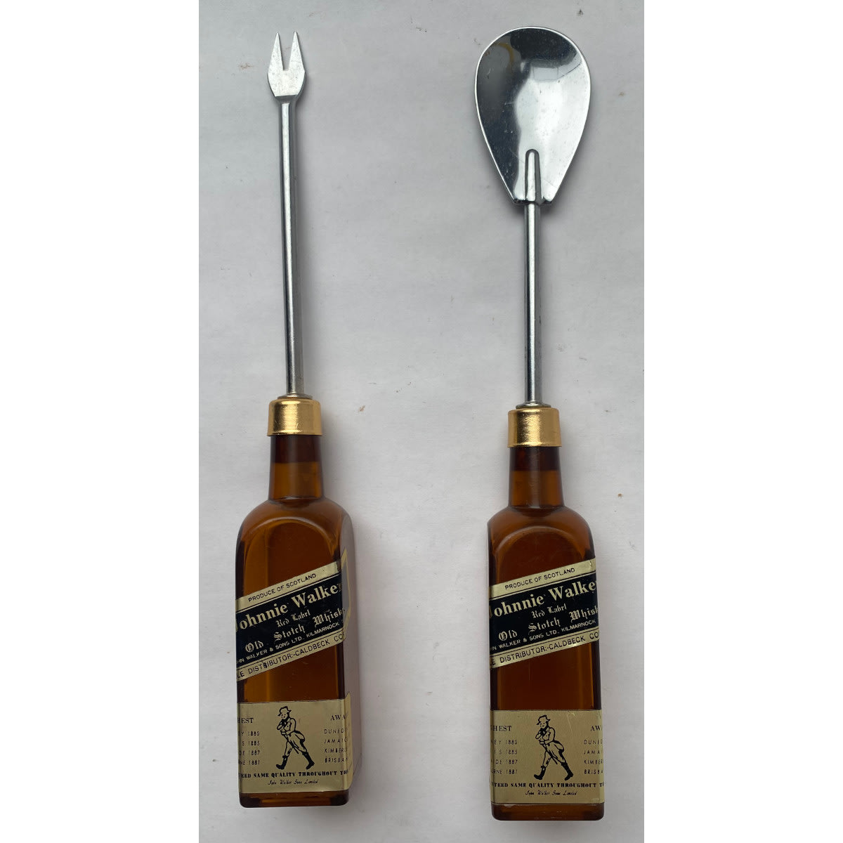 2 Cocktail making utensils. Johnnie Walker black label advertising. Olive fork and a stirring spoon.