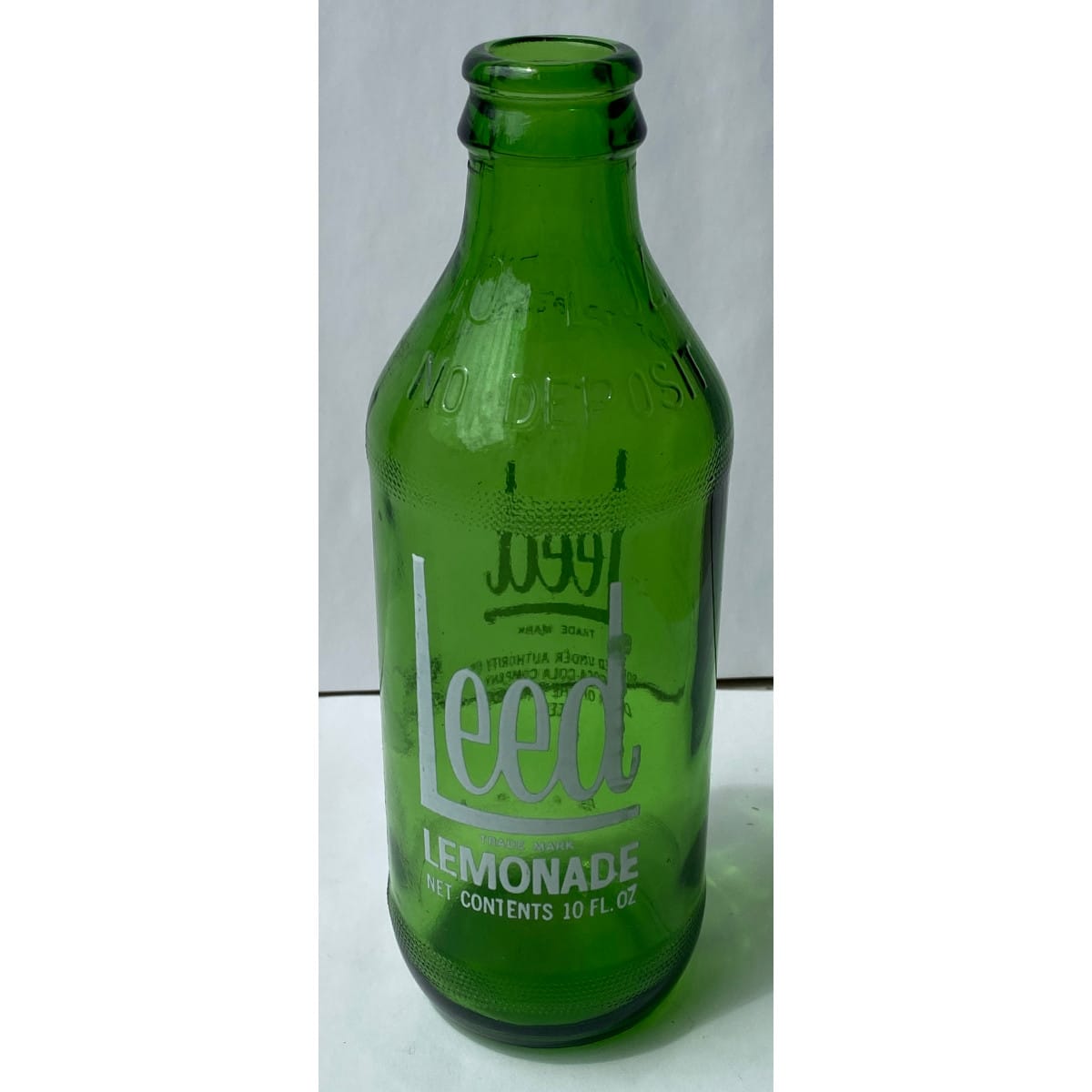 Ceramic Label Crown Seal. Leed Lemonade One Trippa. Coca Cola Company. 10 oz. White print on green.