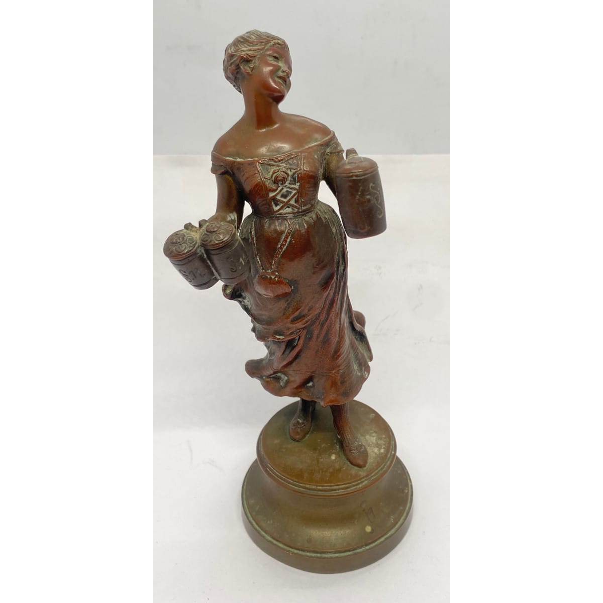 Heavy bronze statuette. Beer maid carrying 3 beer steins. All the mugs have S over S. 11 on them and one has a picture of a monk. Brass base.